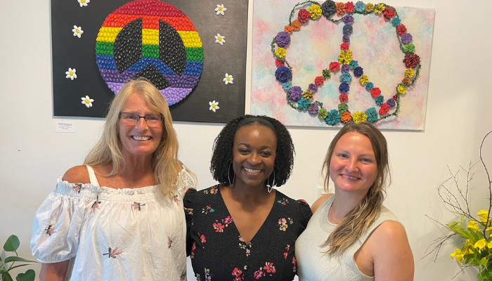 Wave Gallery group picture with peace art behind them