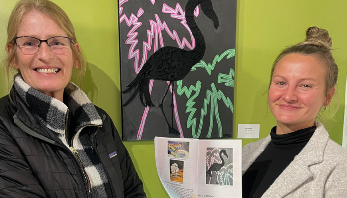 Two women smiling with Art in between