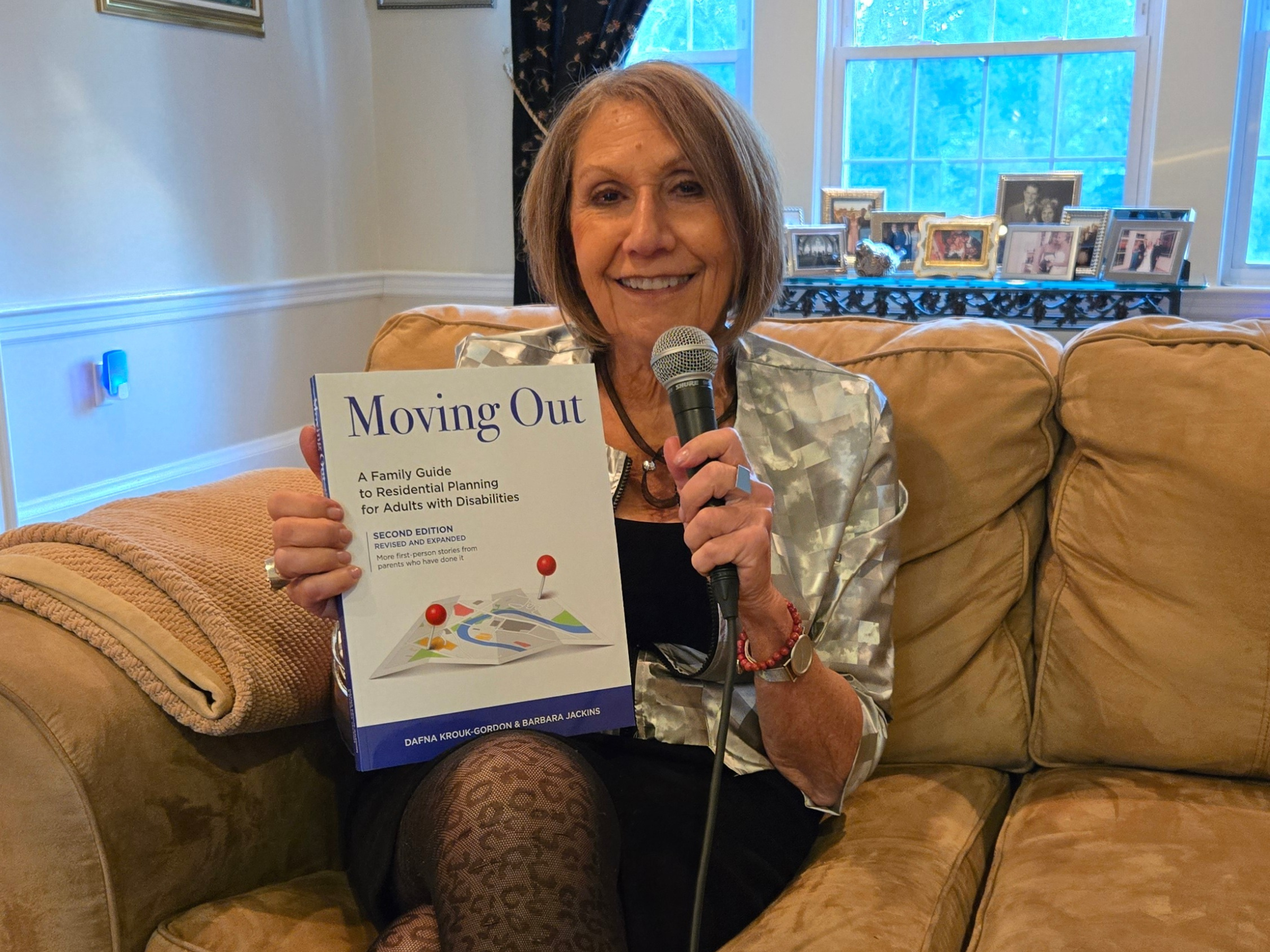 Dafna Holding "Moving Out" book with a Microphone 