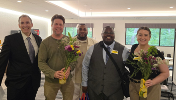 Staff members holding flowers