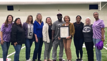 Group of adults holding framed award