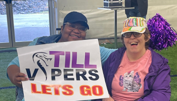 Two women hold let's go TILL vipers sign