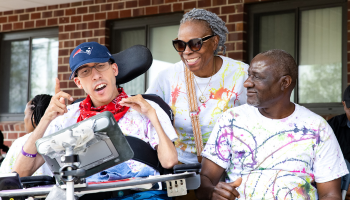 Man in wheelchair with staff members