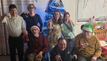 Group photo at a residential home with a Christmas tree