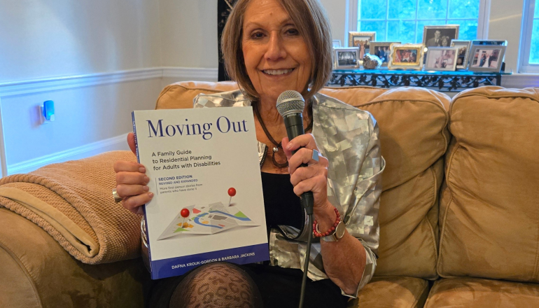 Dafna Holding "Moving Out" book with a Microphone 