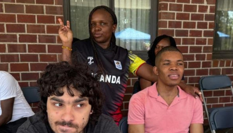 Doreen Natambi holding a peace sign with other individuals in the photo